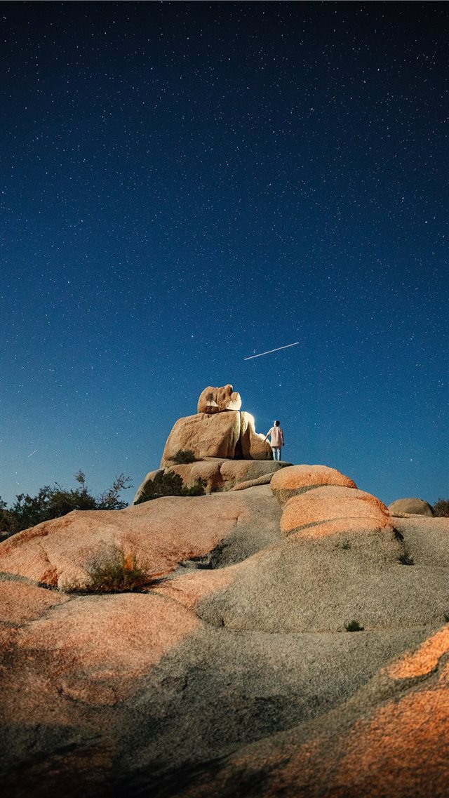 person standing on cliff at night iPhone 8 wallpaper 