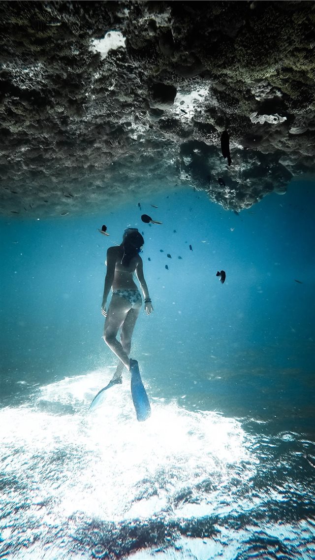 woman underwater wearing blue flippers iPhone SE wallpaper 