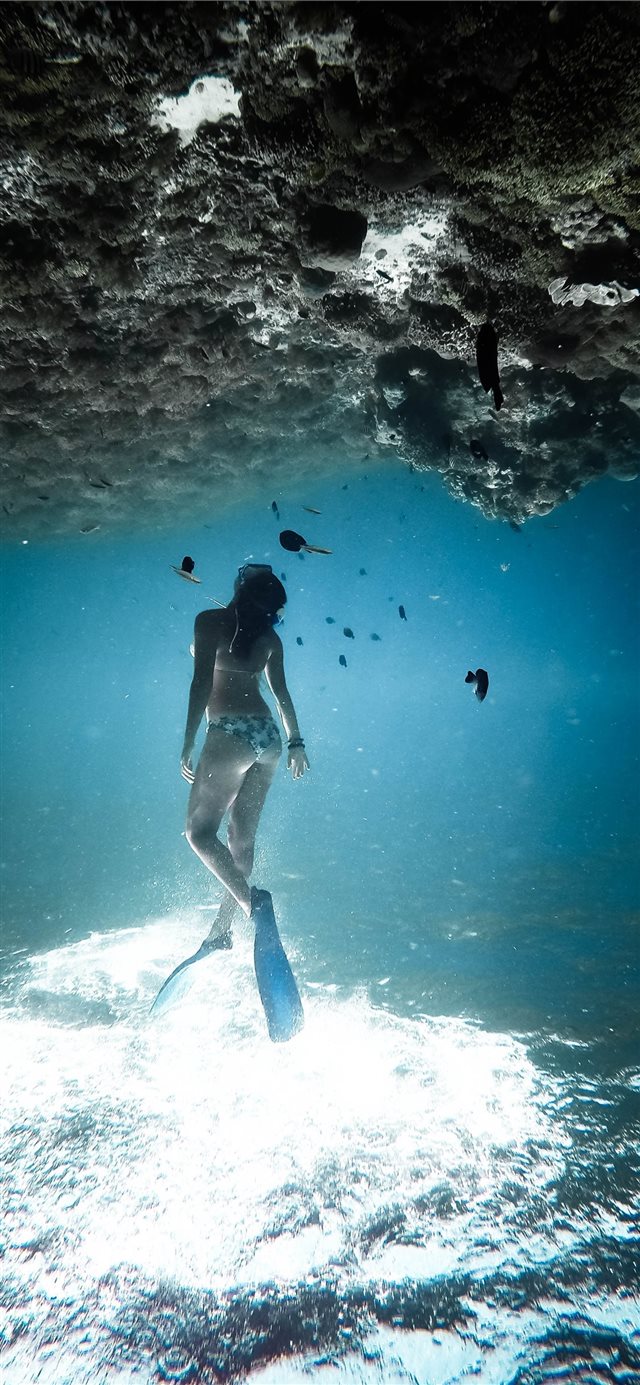woman underwater wearing blue flippers iPhone X wallpaper 