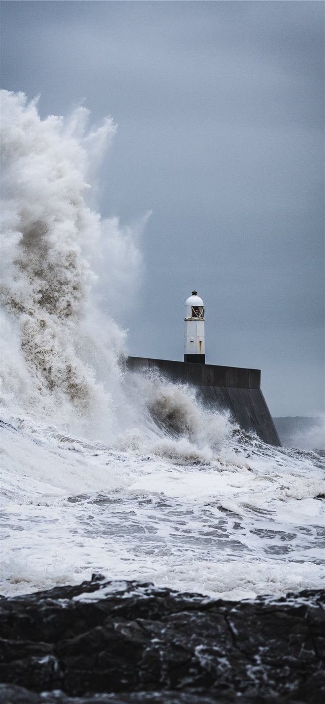 big waves crashing on lighthouse during daytime iPhone 11 wallpaper 