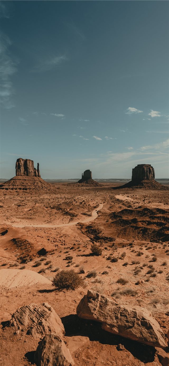 brown rock formation under white clouds during day... iPhone X wallpaper 