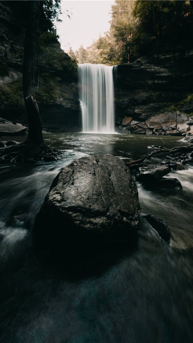water falls on rocky shore during daytime iPhone 8 wallpaper 