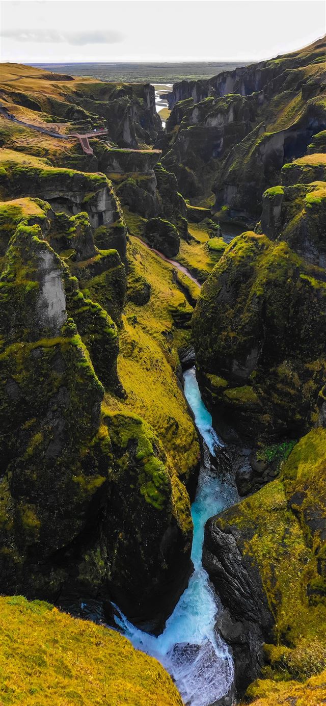 river in the middle of green and yellow mountains iPhone X wallpaper 