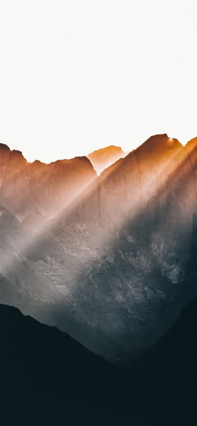 sun beams over mountains iPhone X wallpaper 