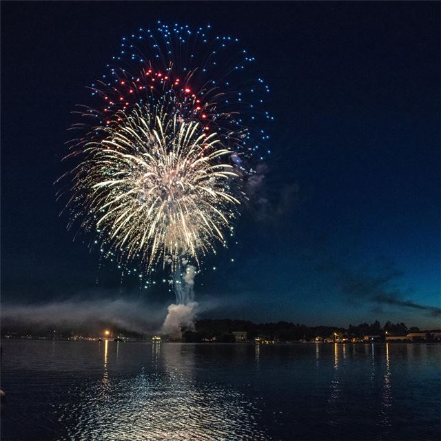 fireworks explosion above water body 8k iPad Pro wallpaper 