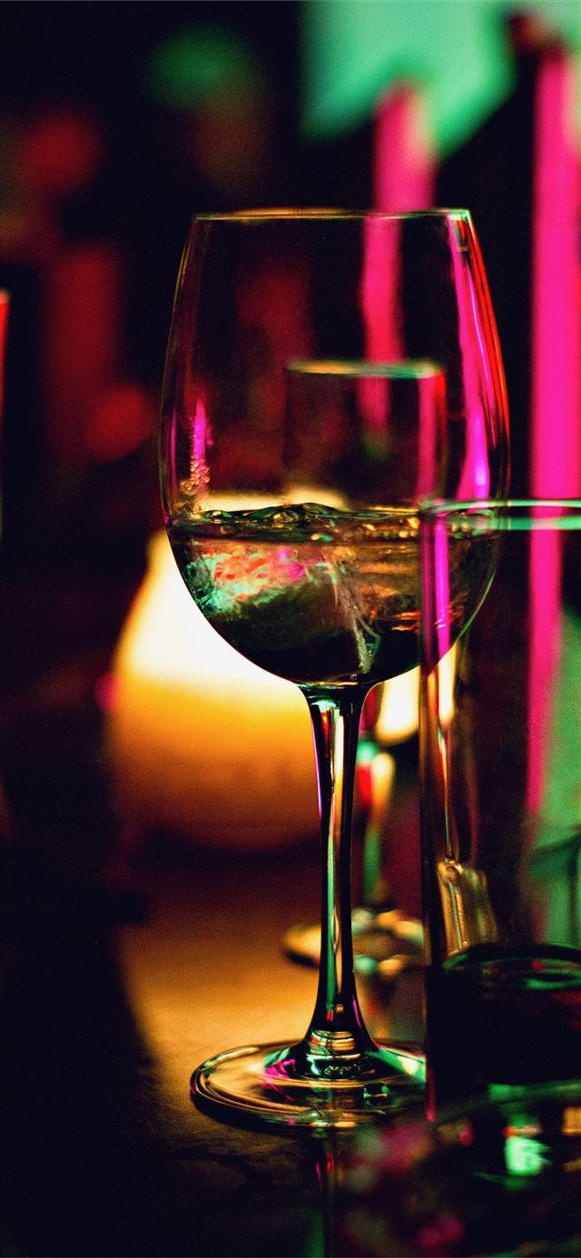 half filled wine glass beside half empty clear pin... iPhone 11 wallpaper 