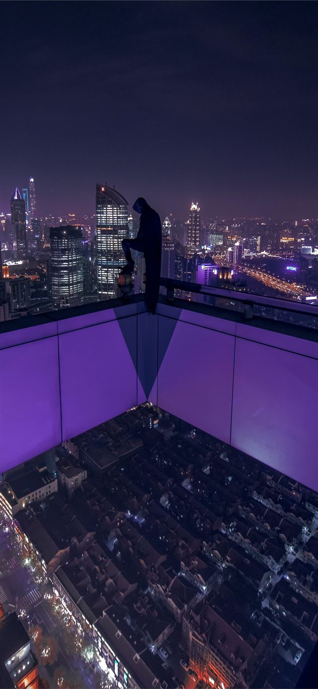 man standing on building rooftop during nigh time iPhone 11 wallpaper 