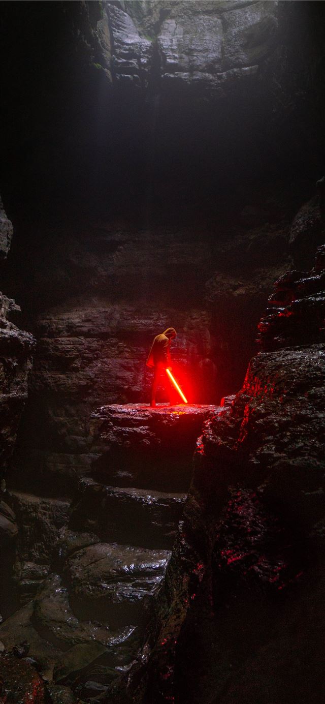 person holding red lightsaber iPhone 11 wallpaper 