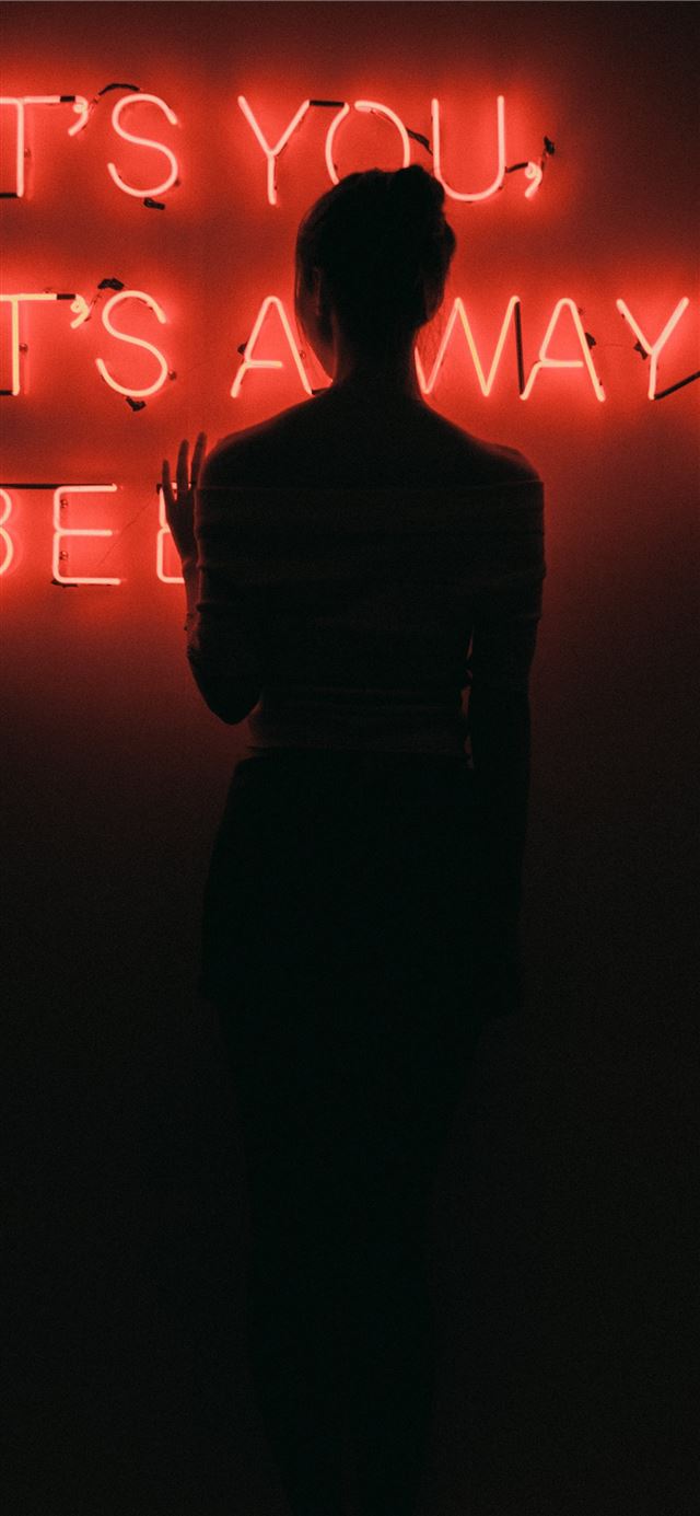 silhouette of woman standing in front of red neon ... iPhone 11 wallpaper 