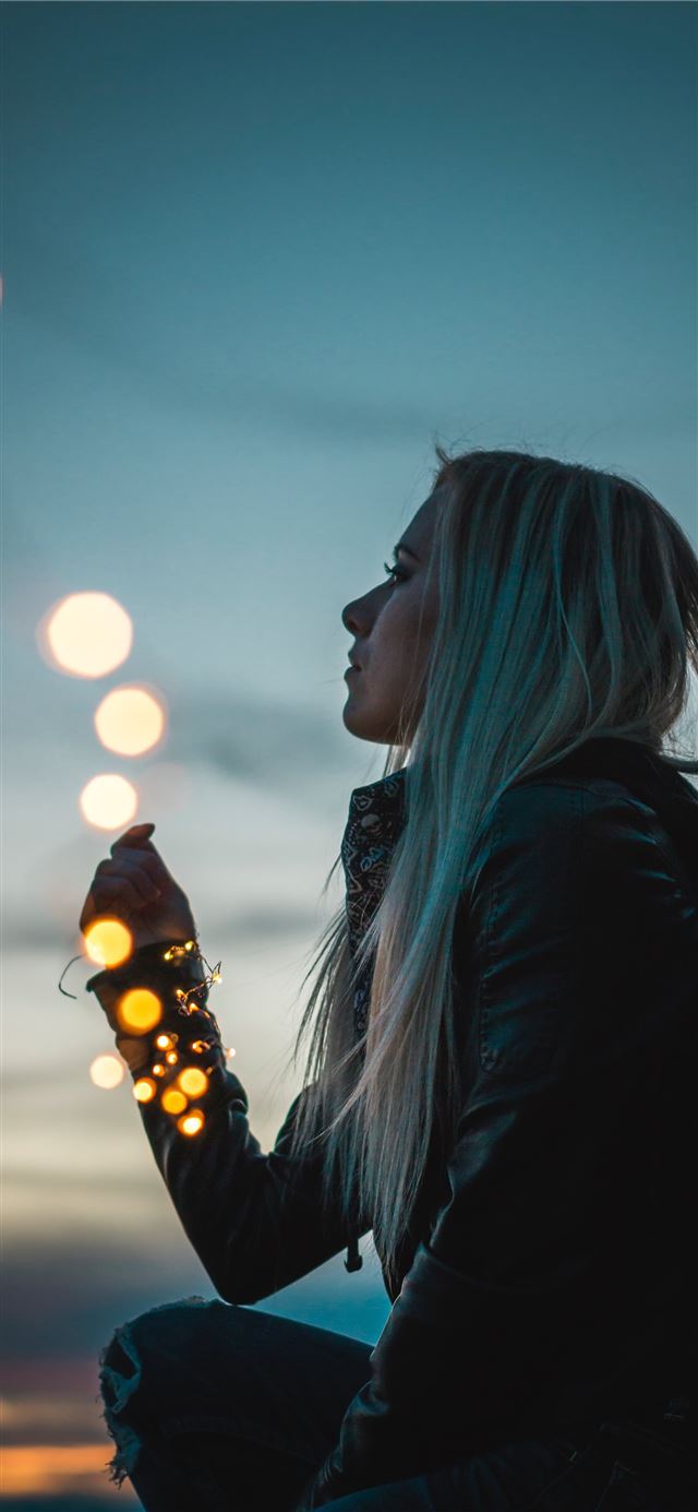 woman sitting holding string lights iPhone 11 wallpaper 