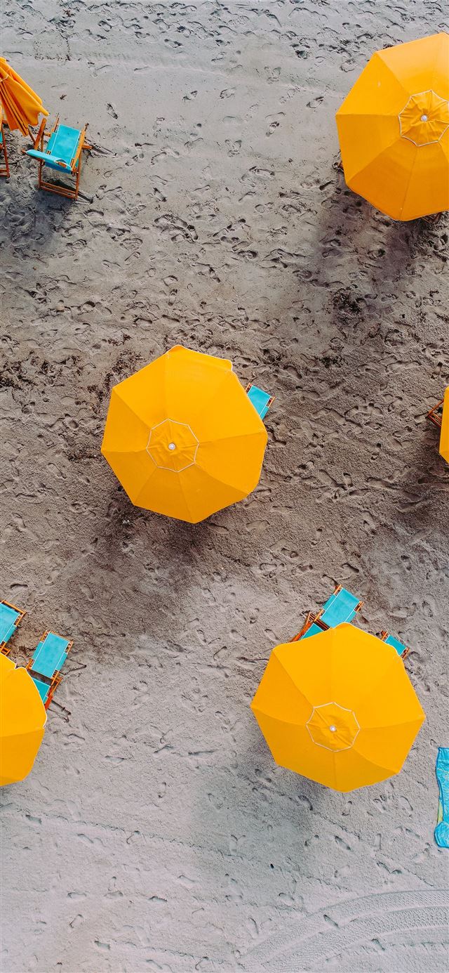 five yellow umbrellas on sand at daytime iPhone 11 wallpaper 