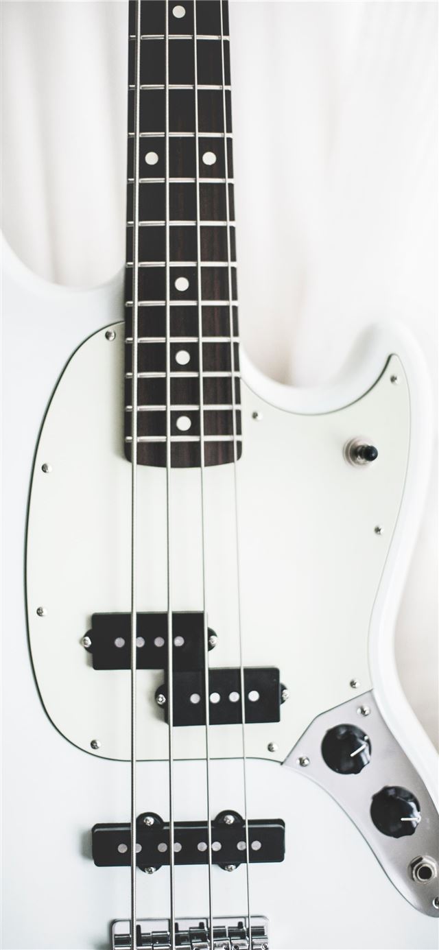 white and black electric bass guitar on white surf... iPhone 11 wallpaper 