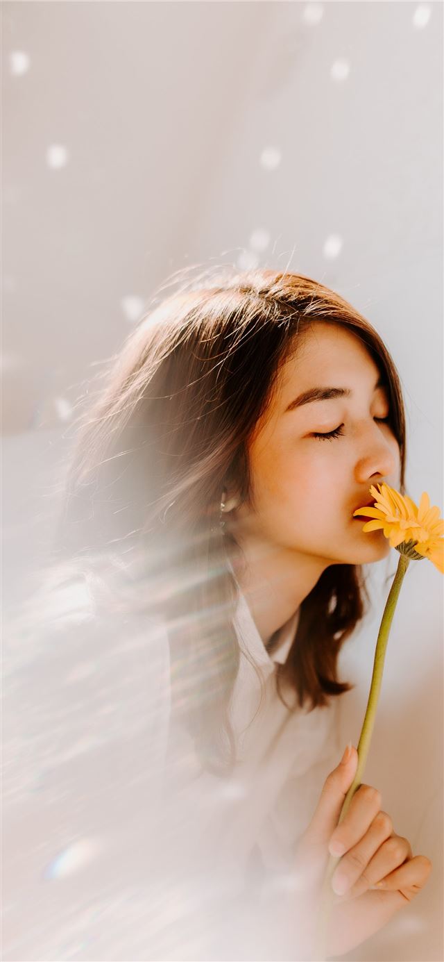 woman smelling on yellow flower iPhone 11 wallpaper 