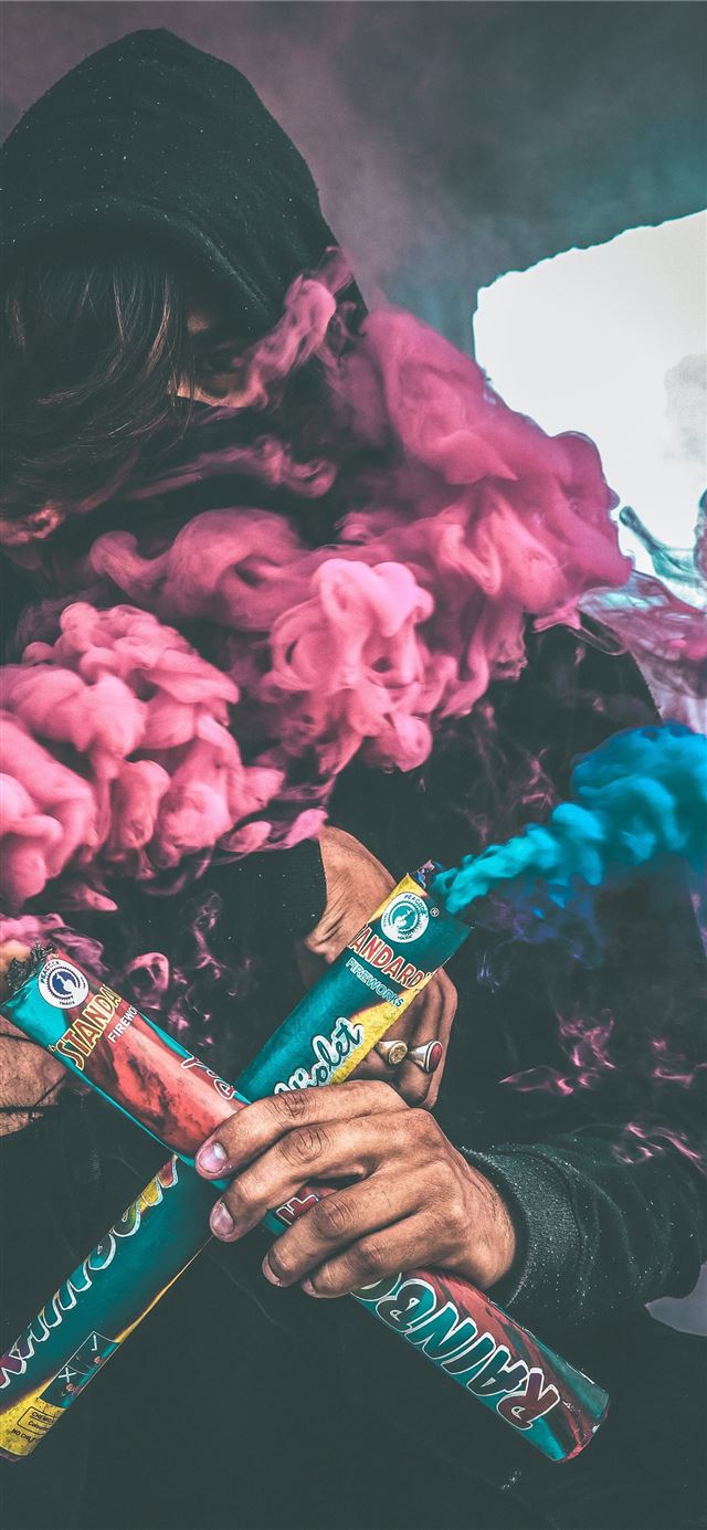 person holding colored smoke iPhone 11 wallpaper 