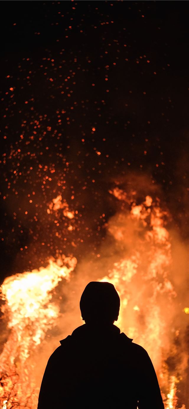 person standing in front of fire iPhone 11 wallpaper 
